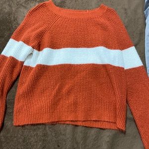 It’s more of a orange red color, sweater with a white stripe